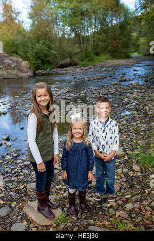 Trois enfants qui sont frères et sœurs dans un style franc à l'extérieur photo le long des rives de la rivière McKenzie dans l'Oregon. Banque D'Images