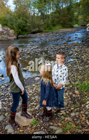 Trois enfants qui sont frères et sœurs dans un style franc à l'extérieur photo le long des rives de la rivière McKenzie dans l'Oregon. Banque D'Images