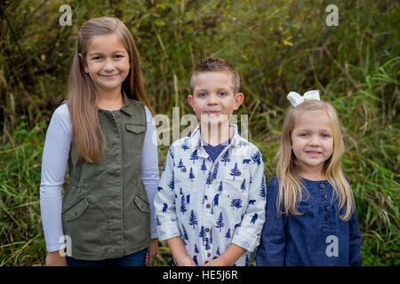 Trois enfants qui sont frères et sœurs dans un style franc à l'extérieur photo le long des rives de la rivière McKenzie dans l'Oregon. Banque D'Images