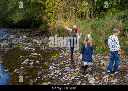 Trois enfants qui sont frères et sœurs dans un style franc à l'extérieur photo le long des rives de la rivière McKenzie dans l'Oregon. Banque D'Images