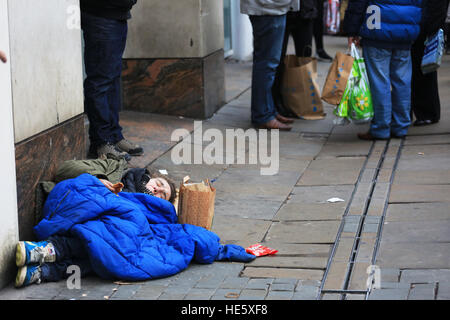 Manchester, UK. 17 Décembre, 2016. Avec leurs acheteurs se leva tandis qu'un commercial rough Sleeper est situé sur la rue, Manchester, 17 décembre 2016 (C)Barbara Cook/Alamy Live News Banque D'Images