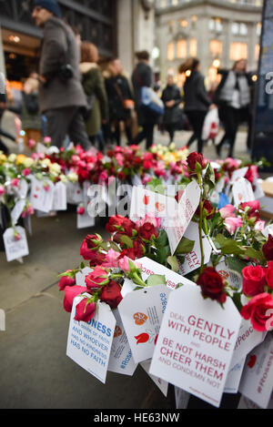 Oxford Street, Londres, Royaume-Uni. Au 18 décembre 2016. 'Les Roses pour la paix" Jeunes femmes musulmanes distribuent des roses aux acheteurs sur Oxfrord Street aujourd'hui. Crédit : Matthieu Chattle/Alamy Live News Banque D'Images