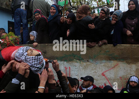 18 décembre 2016 - Ramallah, Cisjordanie, territoire palestinien - pleureuses portent le corps du peuple palestinien Ahmed al-Remawi, lors de ses funérailles dans le village de Beit Rima, près de Ramallah. Ministère de la santé palestinien a déclaré Ahmed a été tué par les forces israéliennes le Dimanche lors d'affrontements. (Crédit Image : © Shadi Hatem/APA des images à l'aide de Zuma sur le fil) Banque D'Images