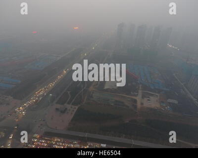 Zhengzh Zhengzh, Chine. Dec 18, 2016. Zhengzhou, Chine 18 décembre 2016 : (usage éditorial uniquement. Chine OUT) .Le smog lourds suaires Zhengzhou, capitale de la province du Henan en Chine centrale, Décembre 18, 2016. Le pire pollution de l'air jusqu'à présent cet hiver commencent à s'installer dans les régions du nord de la Chine, Henan, Shandong, Shanxi, Hebei, Tianjin et Pékin le 16 décembre et devrait durer plus de cinq jours. L'alerte rouge pour la pollution atmosphérique a été émis et les mesures d'urgence ont été prises pour lutter contre le smog. © SIPA Asie/ZUMA/Alamy Fil Live News Banque D'Images