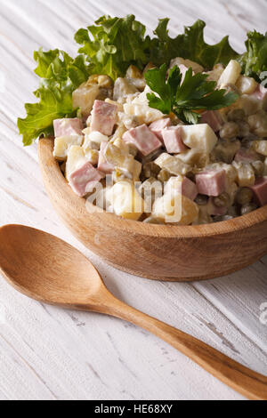 Salade Russe Olivier close up dans un bol en bois sur la table. La verticale Banque D'Images