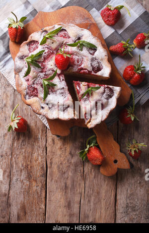 Tarte sucré fraise rustique sur une planche à découper. vertical vue d'en haut Banque D'Images