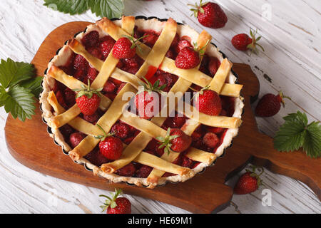 Tarte aux fraises faite maison et de baies fraîches dans un plat allant au four, sur la table. vue horizontale de dessus, rustique Banque D'Images