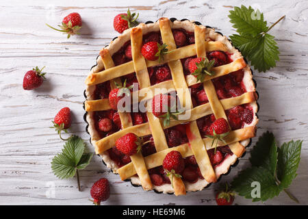 Tarte aux fraises avec les baies fraîches dans le plat de cuisson sur la table. vue horizontale à partir de ci-dessus, style rustique Banque D'Images