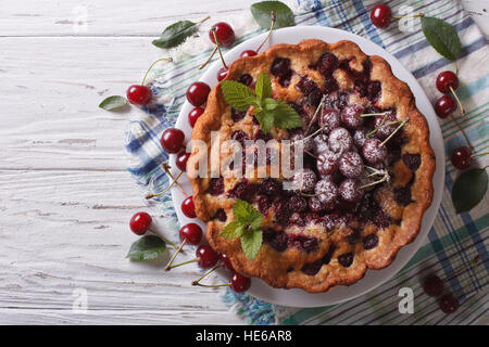 Cerise sur le gâteau fait maison une assiette sur la table. vue horizontale d'en haut Banque D'Images