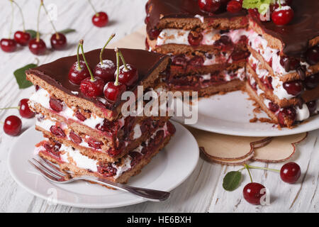 Un morceau de gâteau au chocolat avec des cerises sur une plaque horizontale. Banque D'Images