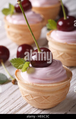 Petits gâteaux aux cerises fraîches et crème onctueuse. Gros plan vertical Banque D'Images