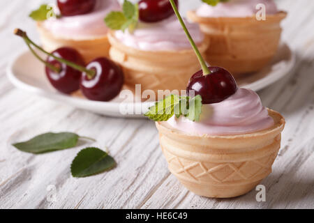Tartelette délicieuse crème et rose avec des cerises mûres close up sur la table horizontale. Banque D'Images