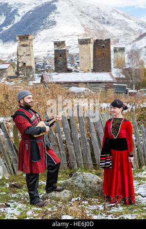 Homme géorgien en costumes nationaux jouant un instrument de musique local de Panduri à Ushguli, Géorgie. Banque D'Images