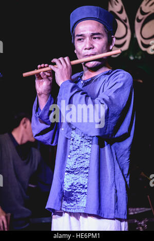 L'homme en costume traditionnel vietnamien jouant de la flûte de bambou Banque D'Images