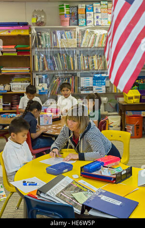 Thoreau, Nouveau Mexique - Enseignant Denise Whelan travaille avec un élève dans une classe de maternelle à saint Bonaventure Indian School. Banque D'Images