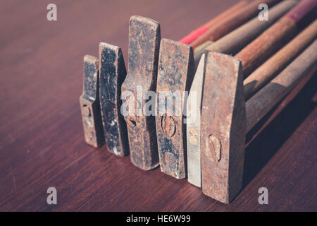 Rangée de vieux marteaux sur table en bois Banque D'Images