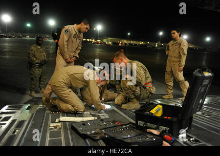 Aviateurs du 455 e Escadron expéditionnaire port aérien, Air de Bagram, en Afghanistan, et la 60e Escadre, de mobilité aérienne Travis Air Force Base, en Californie, la réparation d'un panneau de plancher avant de charger le MRAP Véhicules tout-terrain sur un C-17 de la Base aérienne de McChord, Washington, le 11 août, 2014. La mobilité de l'air est un élément clé de l'opération Enduring Freedom en régression des personnes et de l'équipement tout au long de l'Afghanistan, le 31 décembre 2014, les approches. L'aérodrome de Bagram est le plus achalandé port aérien dans le département de la Défense. Le major Brandon Lingle Banque D'Images