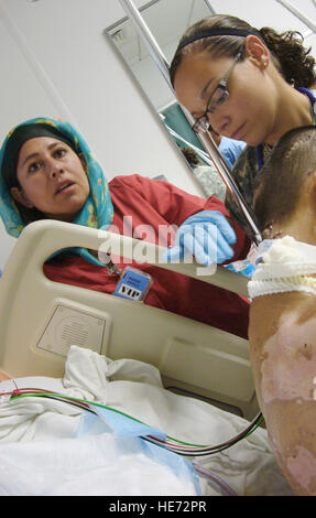 Soldat de l'Armée nationale afghane Laila Farahi (à gauche) aide 1st. Le lieutenant Nicole prises avec un patient le 14 octobre 2009, à l'aérodrome de Bagram, en Afghanistan. Le Lieutenant prises est une infirmière de soins intensifs déployés à partir de la David Grant Medical Center à Travis Air Force Base, en Californie. Banque D'Images