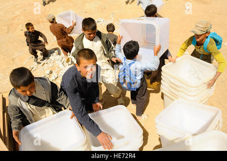 De jeunes Afghans aider à décharger du matériel de scrutin un hélicoptère Mi-17 dans Jaghuri, Afghanistan, le 16 septembre 2010. Les bulletins sont pour le prochain 18 Septembre élections lorsque les Afghans pourront élire la chambre basse du parlement. Banque D'Images