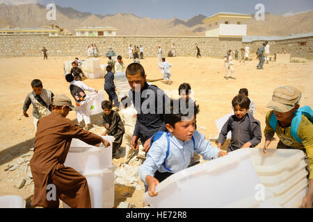 De jeunes Afghans aider à décharger du matériel de scrutin un hélicoptère Mi-17 dans Jaghuri, Afghanistan, le 16 septembre 2010. Les bulletins sont pour le prochain 18 Septembre élections lorsque les Afghans pourront élire la chambre basse du parlement. Banque D'Images