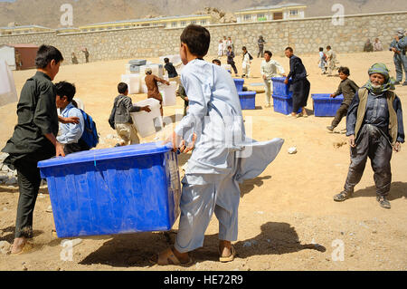 De jeunes Afghans aider à décharger du matériel de scrutin un hélicoptère Mi-17 dans Jaghuri, Afghanistan, 16 septembre. Les bulletins sont pour le prochain 18 septembre, élections lorsque les Afghans pourront élire la chambre basse du parlement. Banque D'Images