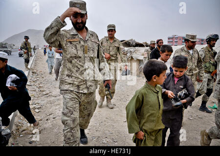 L'ordre civil afghan Police (ANCOP) d'officiers à pied avec les enfants à l'extérieur d'un camp de réfugiés à Kaboul, Afghanistan, le 28 juillet 2011. Membres de l'ANCOP a visité le camp de vérifier sur les familles qui y vivent et d'offrir des boîtes des vêtements donnés par un organisme de bienfaisance dans le New Jersey. Christopher Hatch Senior Airman Banque D'Images