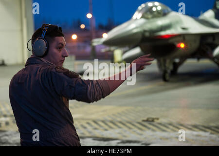 Les cadres supérieurs de l'US Air Force Airman Nathaniel Moore, chef d'équipe affectée au 354e Escadron de maintenance, se prépare à lancer un avion F-16 Fighting Falcon sur Eielson Air Force Base, Alaska, le 17 janvier 2015, pour le voyage à Joint Base Harbor-Hickam Pearl, Mississippi, et Andersen Air Force Base, Guam. Plus de 150 responsables tiendra le 18e escadron agresseur dans l'air pendant la sentinelle ALOHA ET FAIRE FACE AU NORD, qui sont destinées à préparer les aviateurs américains, marins et marines, ainsi que les partenaires de la coalition dans le théâtre des opérations du Pacifique, d'opérations d'urgence si le besoin d'Aris Banque D'Images