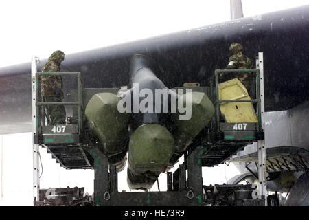 US Air Force (USAF) le personnel affecté à la 23e Bomb Wing (BW), utiliser un pylône maintenance/support de chargement pour charger des missiles de croisière AGM-129 Recherche Avancée sur un B-52H Stratofortress, aéronefs, pendant une tempête, sur la ligne de vol à Minot Air Force Base (AFB), Dakota du Nord (ND), au cours de l'état d'alerte dans le cadre de l'exercice de la vigilance des Prairies de 2002. Banque D'Images