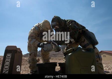 Dans l'US Air Force Explosive Ordnance Disposal aviateurs affecté à la 820e Escadron Cheval Rouge wrap bandage de plâtre de Paris autour d'un cycle chimique lors d'un exercice d'entraînement, le 14 août 2012, à Nellis Air Force Base, Nevada Le plâtre commence comme une poudre semblable à mortier ou du ciment et est mélangé avec de l'eau pour former une pâte qui durcit. Navigant de première classe Christopher Tam) Banque D'Images