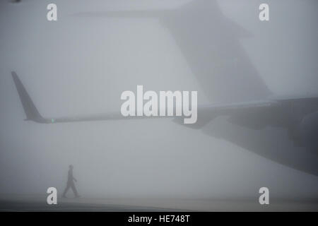 Navigant de première classe, de l'Anthony Mahon 436e Airlift Wing, effectuer une inspection visuelle sur un C-17 Globemaster III au cours d'épais brouillard avant le lancement de l'avion de la Base Aérienne de Dover, Delaware, 17 mars 2016. Les réservistes expérimentés du 512th Airlift Wing train fréquemment des aviateurs en service actif dans diverses tâches sur le terrain de carrière. Le Capitaine Bernie Kale) Banque D'Images