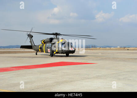 Un hélicoptère d'évacuation médicale Black Hawk à partir du 3e Bataillon de soutien général à l'aviation de l'armée américaine Garrison Humphreys, République de Corée, des terres au cours d'une évacuation sanitaire et de poussière dans le cadre du scénario de l'exercice de l'état de préparation opérationnelle Beverly minuit 14-02 à Osan Air Base, République de Corée, le 12 février 2014. Les soldats de la 3-2 GSAB pratiqué ramasser des victimes simulées à partir de la simulation de missions de terrain et à leur transport à Osan pour traitement médical. Navigant de première classe Ashley J. Thum) Banque D'Images