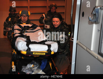 Le capitaine Peter Lee, 51e Escadron dentaire dentiste général, et Tech. Le Sgt. Kimberly Cruickshank, 51e Escadron en médecine aérospatiale médecine vol sous-officier responsable, placez une civière dans une ambulance après avoir livré deux faux blessés à la 51e Groupe médical au cours d'une salle d'urgence et d'évacuation sanitaire hors-poussière scénario comme partie de l'exercice de l'état de préparation opérationnelle Beverly minuit 14-02 à Osan Air Base, République de Corée, le 12 février 2014. Les deux faisaient partie d'une équipe de quatre personnes qui ont effectué trois voyages vers et à partir de la ligne de vol offrant cinq victimes d'une maquette au sol simulé à l'urgence de l'engagement d'advanc Banque D'Images