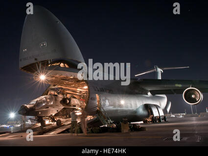 Aviateurs et soldats charger un AH-64 Apache de l'Armée américaine à bord d'un hélicoptère d'attaque U.S. Air Force C-5B Galaxie Air à Bagram, en Afghanistan, le 31 août 2012. C-5 d'équipage et les responsables de la West Virginia Air National Guard's 167e Airlift Wing ont été positionnés à Bagram pour aider à la relève sur place/transfert d'autorité de l'aviation de combat et 82e Brigade arrivant 101e Brigade d'aviation de combat. Banque D'Images