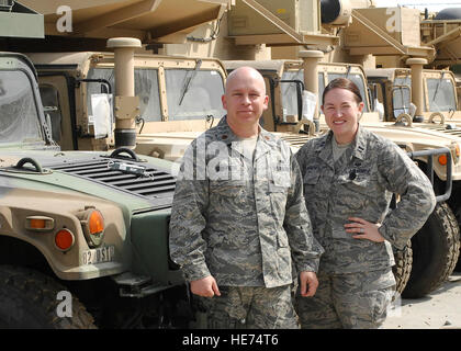 Le major Tobin Griffeth et Capt Katie Illingworth, contrat et l'exercice des avocats avec Combined Joint Task Force 82's Bureau du Juge-avocat personnel tenir ensemble en face d'un grand groupe de Humvees. Le major Griffeth et le capitaine Illingworth a créé un jeu qui permettrait de recueillir l'énergie de support du ventilateur pour l'Université du Texas et l'Oklahoma est chauffée la rivalité. Dons de vêtements, chaussures et fournitures scolaires sont envoyés dans le duo où l'aide de la distribuer à l'échelle du pays pour des patrouilles au sol pour aider le peuple afghan. "Cette guerre sera une personne à la fois, et par le biais des enfants,' Le major Griffeth sai Banque D'Images