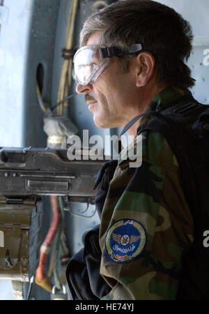 Un hélicoptère MI-17 mitrailleur de porte de l'armée nationale afghane (ANA) air corps, garde un œil attentif lors d'une mission le 25 juillet, l'avion de l'aéroport international de Kaboul (KIA) de l'Afghanistan. Les membres de l'US Air Force agir comme mentors pour les soldats de l'ANA et sont affectés à la transition conjointe de la sécurité (CSTC-A) basé sur le Camp Eggers, Kaboul, Afghanistan. La CSTC-A s'associe avec le Gouvernement de la République islamique d'Afghanistan et la communauté internationale, à un plan, un programme, et de mettre en œuvre des politiques structurelles, organisationnelles, institutionnelles et de gestion des réformes de l'Afghanistan Banque D'Images