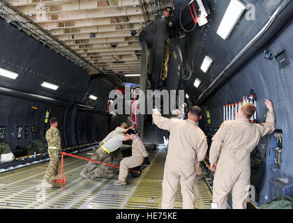 Des soldats américains affectés à la 96e Bataillon de soutien à l'aviation, la 101e Brigade d'aviation de combat, et aviateurs canadiens affectés à la 9ème escadron de transport aérien de la Base Aérienne de Dover, Delaware, travailler ensemble à identifier et positionner une armée UH-60 Black Hawk pendant un téléchargement sur un C-5 Galaxy Super avion le 26 avril 2015, Air à Bagram, en Afghanistan. Tout au long du mois d'avril, plusieurs hélicoptères ont été chargés et transportés aux États-Unis afin de faciliter l'échange de l'Armée 82e et 101e brigades d'aviation de combat. Le s.. Whitney Amstutz Banque D'Images