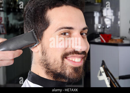 Close up of young man ayant une coupe de cheveux avec les clippers. Banque D'Images