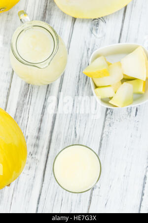 Fait frais smoothie melon de miel (close-up shot, selective focus) sur une table en bois Banque D'Images