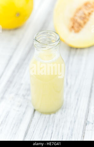 Fait frais smoothie melon de miel (close-up shot, selective focus) sur une table en bois Banque D'Images