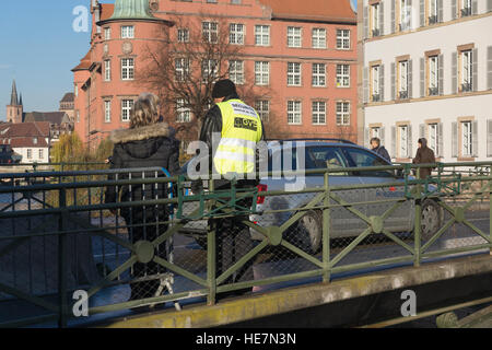 Un garde de sécurité examine les sacs chez une entrée de la zone de marché de Noël de Strasbourg à la suite de l'arrestation de terroristes ISIS Banque D'Images