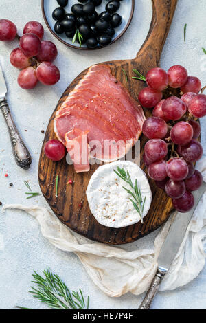La plaque d'entrée avec de la viande, les raisins, le fromage et les olives. Antipasti tapas ou concept. Vue d'en haut Banque D'Images