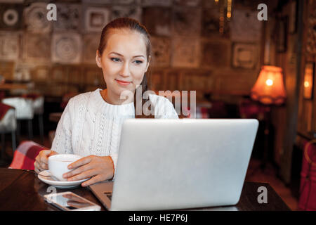 Yong femme un travail à laptop in cafe Banque D'Images