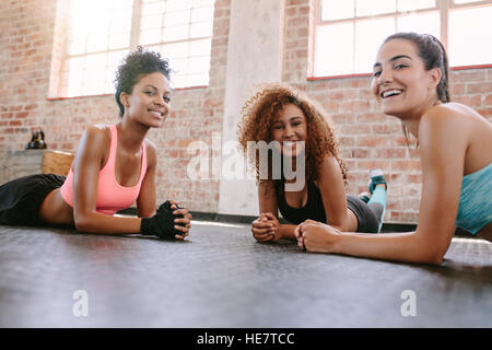 Portrait de trois jeunes femmes en cours de conditionnement physique à la caméra et au sourire. Les amis des femmes exerçant ensemble en cours de conditionnement physique. Banque D'Images