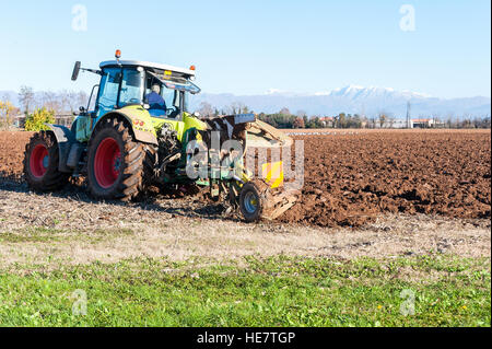 Tracteur avec charrue. Champ de labour à sunny day Banque D'Images