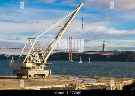 Une grue à l'extérieur musée vintage MAAT, 25 avril suspension bridge et "Cristo Rei" statue du Christ au-delà de Lisbonne, Portugal Banque D'Images