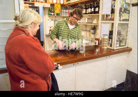 Une femme l'achat d'un shot de liqueur de cerise aigre ginja, Eduardino bar, Rua das Portas de Santo Antão, Lisbonne, Portugal Banque D'Images