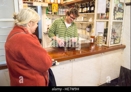 Une femme l'achat d'un shot de liqueur de cerise aigre ginja, Eduardino bar, Rua das Portas de Santo Antão, Lisbonne, Portugal Banque D'Images