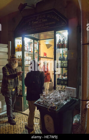 Une femme l'achat d'un shot de liqueur de cerise aigre ginja, Eduardino bar, Rua das Portas de Santo Antão, Lisbonne, Portugal Banque D'Images