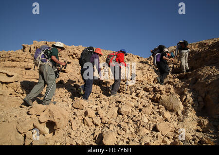 Un groupe de citoyens âgés sont les randonneurs de l'escalade ou Marzeva Nahal Nahal et monter un rocky mountain dans le désert du Néguev. Banque D'Images