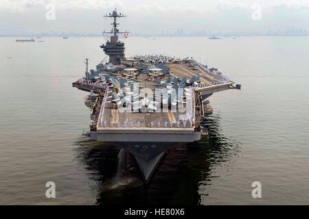 Les marins américains à bord de l'homme les rails de classe Nimitz USN porte-avions USS George Washington comme il soulève ses ancres à quitter la baie de Manille, le 8 septembre 2010 à Manille, aux Philippines. Banque D'Images